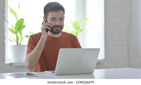 Young Man Talking on Phone at Work - Shutterstock ID 2198106479