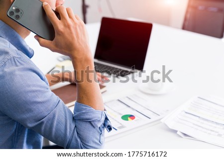 Young man talking on the phone in his home officeWork from home A man at home Freelancer workspace, interior design, office with computer Business chair