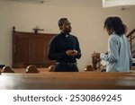 Young man talking to a priest in a church, sharing thoughts and concerns. The priest listens, holding rosary beads. Spiritual ambiance with wooden pews