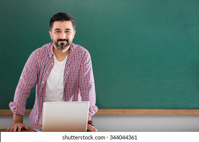 Young Man Teacher Posing In Classroom.