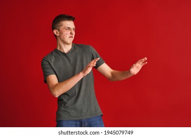 young man, a teenage student, holds out his hand like a stop sign, stop, refusing anything on a brown background. Giving up a bad habit. Fight against smoking,alcoholism, drug addiction, fast food.