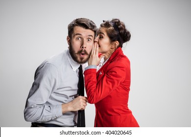 Young man telling gossips to his woman colleague at the office - Powered by Shutterstock