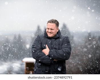 Young man in a thick winter jacket looking critically to the side, outdoor in Winter