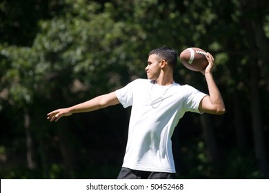 A young man throwing a football outdoors.