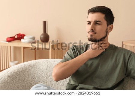 Young man with thyroid gland problem at home