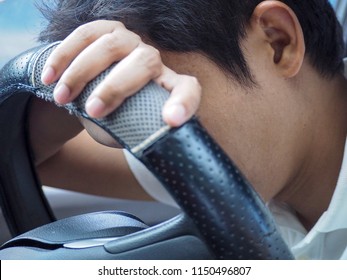Young man tired of fatigue from driving. Take a nap on the steering wheel.close-up