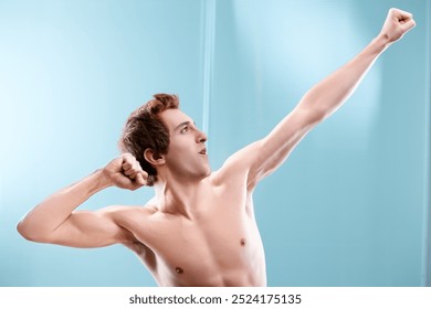 Young man with a toned body humorously celebrates, raising his arm in a victorious gesture, set against a soothing bathroom background - Powered by Shutterstock