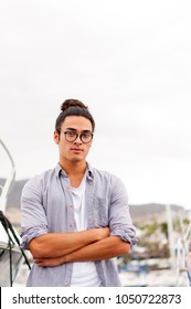 Young Man With The Top Knot And Glasses In The Sea Port