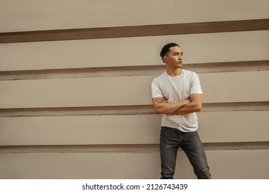 Young Man With Top Knot Lean Back Against The Wall Under The Sunset