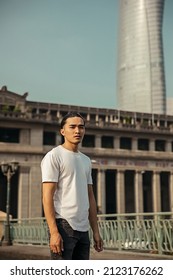 Young Man With Top Knot Standing In The City Under The Sunset