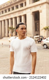 Young Man With Top Knot Standing In The City Under The Sunset