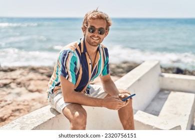 Young man tourist using smartphone sitting on bench at seaside - Powered by Shutterstock