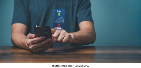 Young man trader trading online on the smartphone apps for buy and sell stock financial market with chart. - Powered by Shutterstock