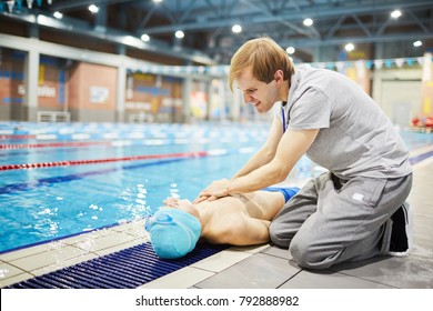 Young man or trainer of swimming giving first aid to one of his learners after accident - Powered by Shutterstock