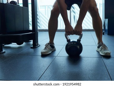 Young Man Is Training By Kettlebell At The Gym