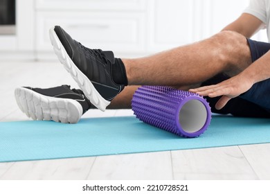 Young Man Training With Foam Roller At Home, Closeup