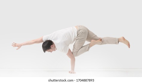 A Young Man Trains Balance In A Gymnastic Stand. Training At Home. Power Gymnastics. Break Dance Air Baby Posture.