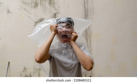 Young Man with a transparent plastic bag on his head. suffocate. face in a plastic bag, strangulation