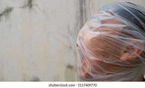 Young Man with a transparent plastic bag on his head. suffocate. face in a plastic bag, strangulation. suffocate