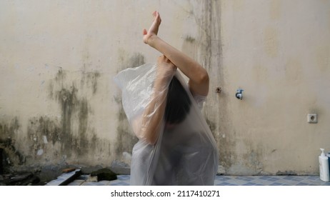 Young Man with a transparent plastic bag wraping his body. suffocate. face in a plastic bag, strangulation. suffocate