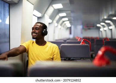 Young man travel by train. Handsome african man listening the music while travel. - Powered by Shutterstock