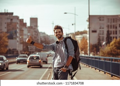 Young man traveler hitchhiking in the city