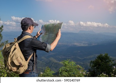 Young Man Traveler with map backpack relaxing outdoor with rocky mountains on background Summer vacations and Lifestyle hiking concept.