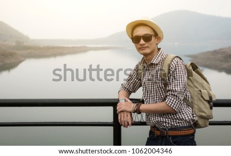 young man with hat in front of mountain panorama