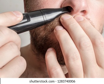 Young Man Trimming Nose Hair Helping Himself With Hands