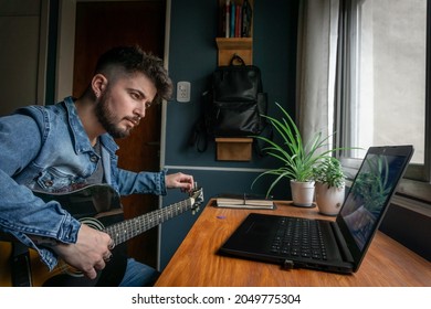 Young Man Trying To Learn Guitar Online