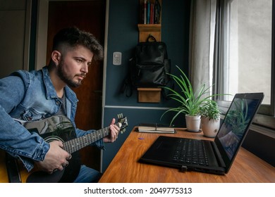 Young Man Trying To Learn Guitar Online