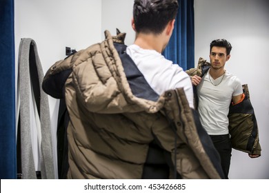 Young Man Trying On Clothes In Clothing Store