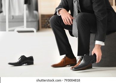 Young Man Trying On Shoes In Shop