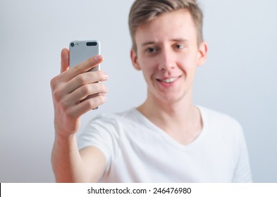 Young Man In T-shirt Holds Phone