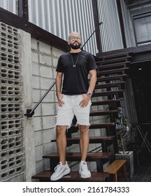 A Young Man In T-shirt And Shorts On The Stairs At City Streets