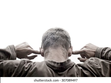 Young man turned back and has his fingers in his ears, against white background