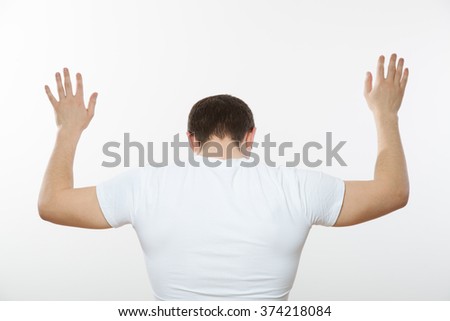 Young man turning back and capitulating, white background