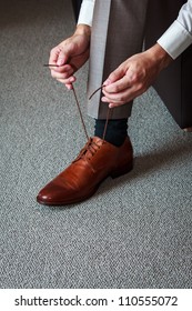 A Young Man Tying Elegant Shoes Indoors