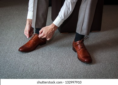 A Young Man Tying Elegant Shoes Indoors