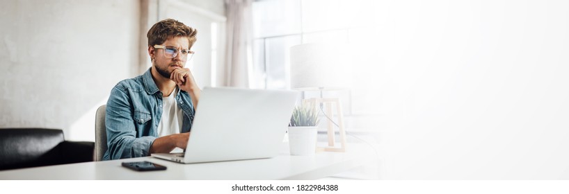 Young Man Typing On Laptop. Modern Businessman At Sunny Office. Freelancer At Work. Blogger Or Journalist Writing New Article. Copy Space For Text