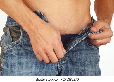 Young Man Unbuttons Blue Jeans Close Up