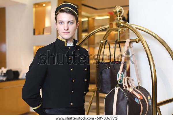 Young man in uniform\
serving in hotel