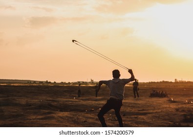 Young Man use Slingshot against Israeil Gaza protests march of return in the border at the Israeil-Gaza border, on October 25, 2019