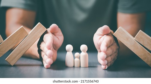 The young man used both of his hands to protect from the falling wooden blocks.,The concept of caring, protecting, protecting family members to be safe and happy.