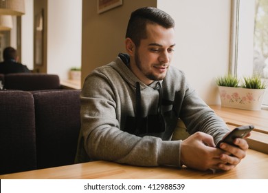 young man uses the phone in a cafe