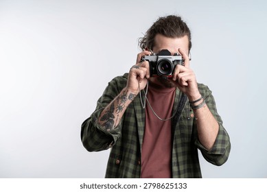 Young man using analog camera isolated on gray background