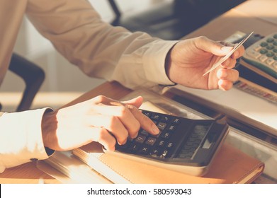 Young man using calculator with credit card for shopping internet online ,selective focus.