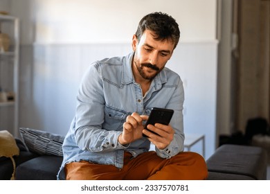 Young man using cellphone for work, social media or relaxation. Smart phone people concept. - Powered by Shutterstock