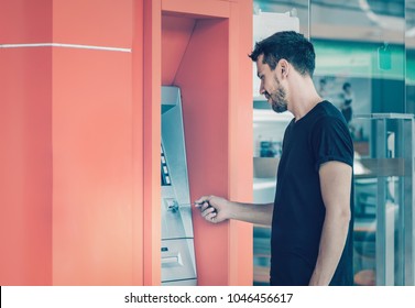 Young Man Using Credit Card For Cash Withdrawal In ATM Machine 