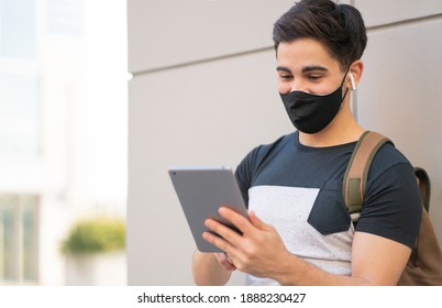 Young man using digital tablet outdoors. - Powered by Shutterstock